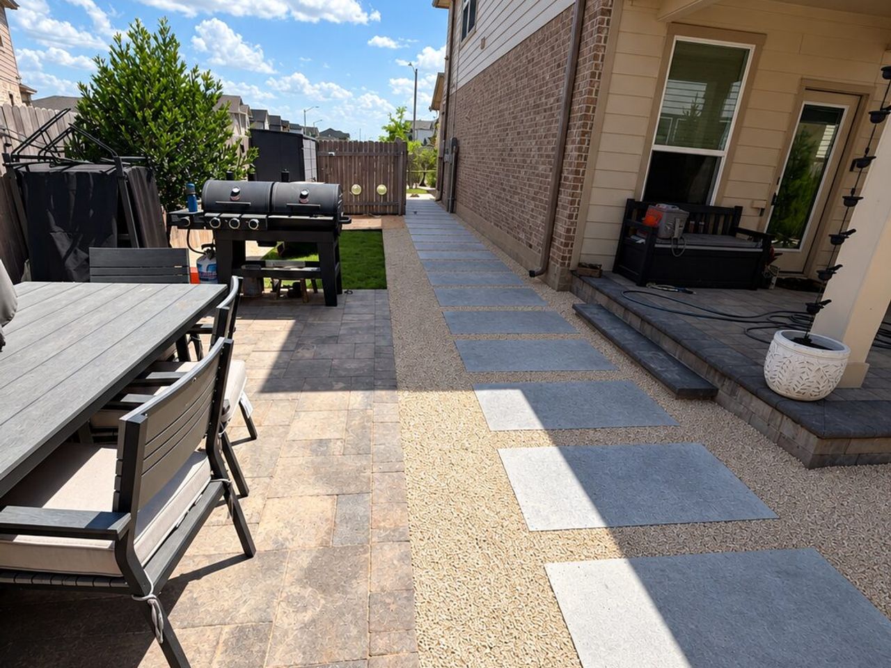 Large concrete stepping stones set in crushed granite running alongside an Austin home