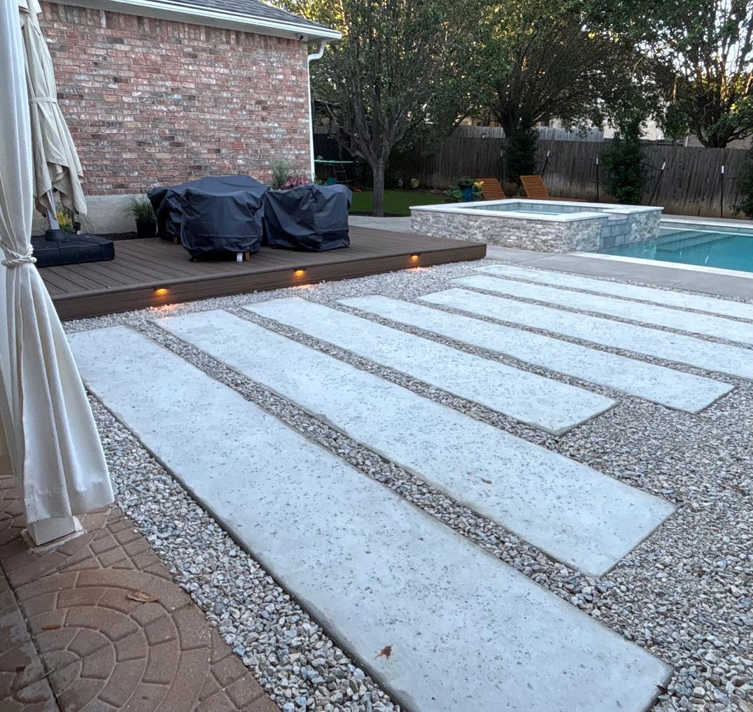 Composite deck with built-in step lights beside a pool and spa, built by GardenGOAT in Austin TX