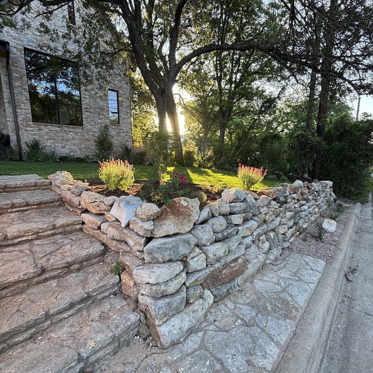 Natural stone steps beside a dry-stacked limestone wall in Austin