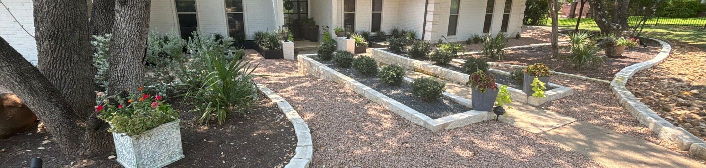 Front yard landscaping in Austin with crushed granite, limestone block borders, and drought-tolerant planting beds