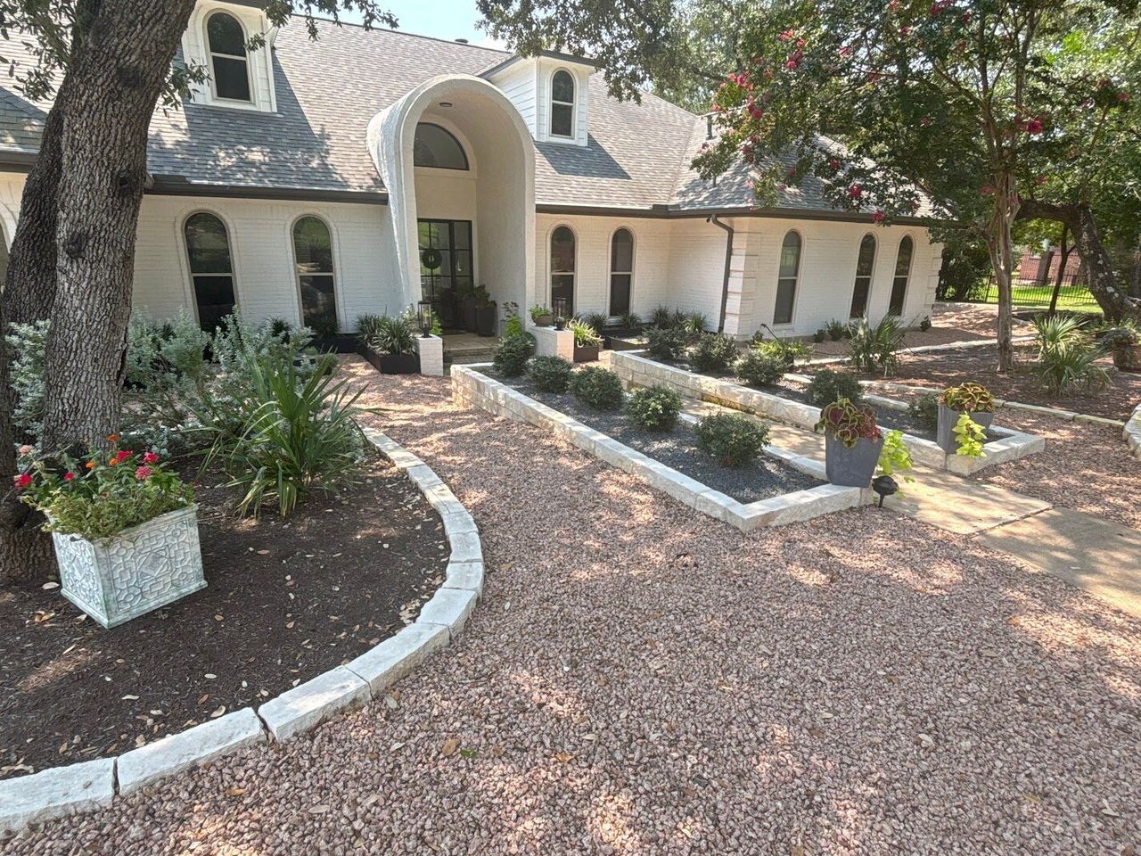 Front yard xeriscape with crushed granite, limestone block borders, and drought-tolerant plants in Austin